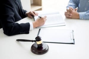 an image that represents aiding and abetting attorney. Judge gavel with lawyers advice legal at law firm in background. Concepts of law, services.